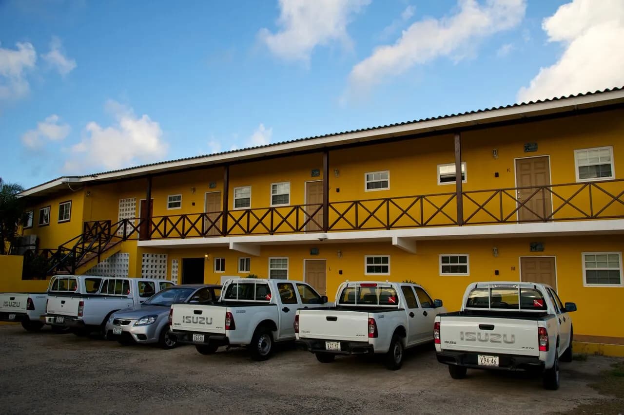 A row of parked trucks in front of a yellow building. A row of parked trucks in front of a yellow building.