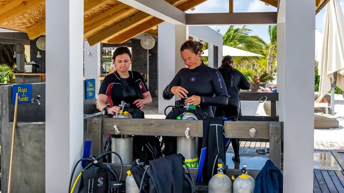 Scuba divers set up their equipment at Delfins Beach Resort Bonaire. Scuba divers set up their equipment at Delfins Beach Resort Bonaire.