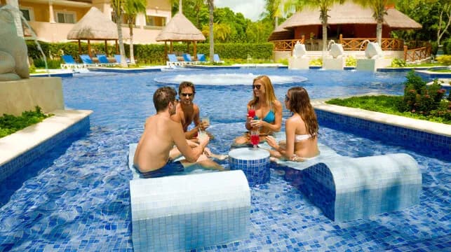 A family enjoys a pool at Barcelo Maya Grand A family enjoys a pool at Barcelo Maya Grand