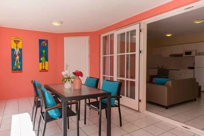 Dining table and living room in a standard apartment at Livingstone Jan Thiel Beach Resort Dining table and living room in a standard apartment at Livingstone Jan Thiel Beach Resort