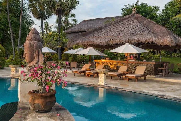 Pool with Balinese decor and sun beds around it Pool with Balinese decor and sun beds around it