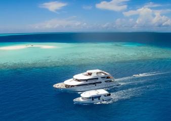 The Carpe Diem and its dive dhoni making its way through the blue waters of the Maldives