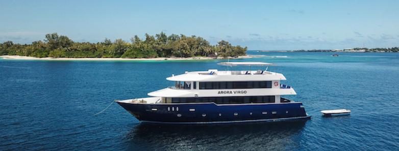 Aurora Virgo sails past an island in the Maldives