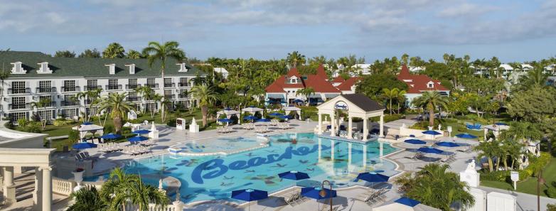 A large pool with the Beaches logo and lounge chairs surrounding it