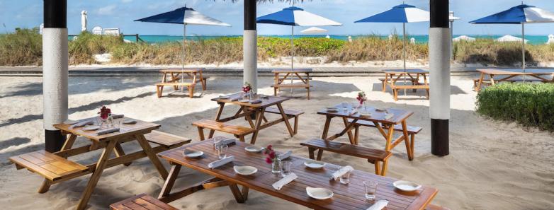 Barefoot By the Sea restaurant with picnic tables in the sand