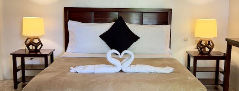 Deluxe Queen Room's large bed with towels folded into swans