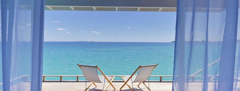 A deck of a deluxe water villa extends over the sea at Kuramathi Island Resort Maldives.