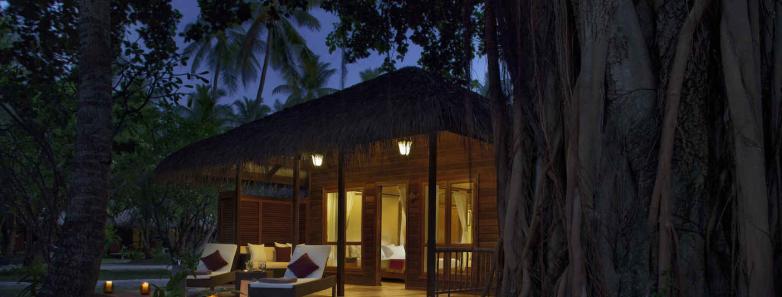 A beach villa lit at night at Kuramathi Island Resort Maldives.