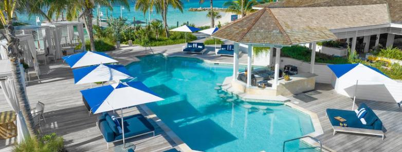 Lounge chairs with umbrellas surrounding the swimming pool