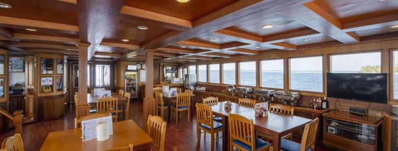 The indoor dining area with chairs, tables and a TV