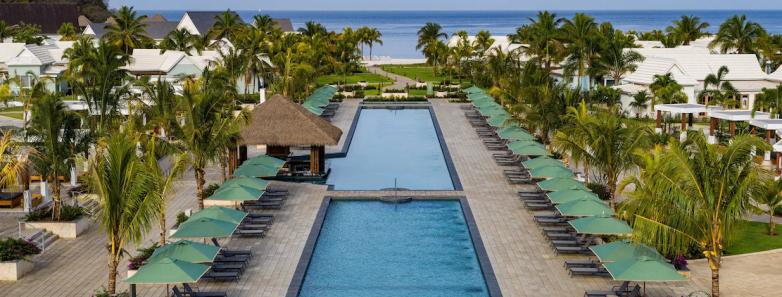 A rectangular pool with umbrellas set up beside it