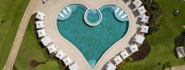 A heart shaped pool surrounded by umbrellas