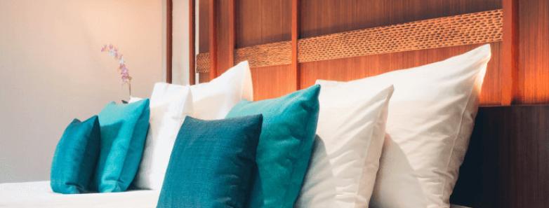 Bed with more blue pillows in the Asmat and Dayak Cabins