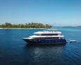 Aurora Virgo sails past an island in the Maldives